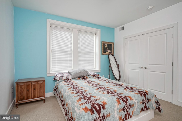 bedroom featuring light carpet and a closet