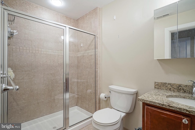 bathroom with an enclosed shower, vanity, and toilet