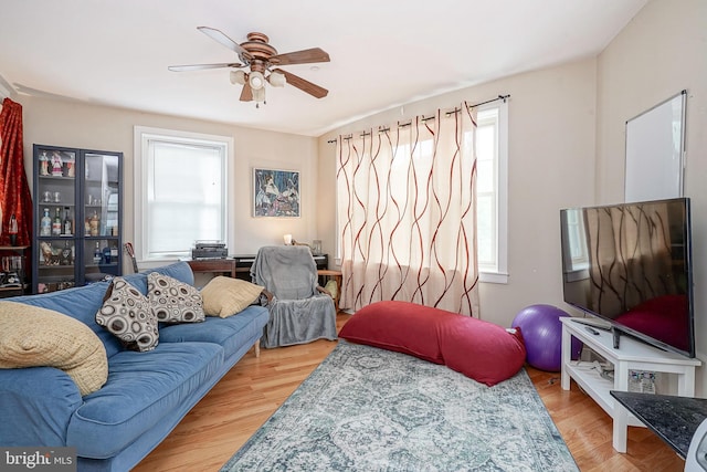 living room featuring light hardwood / wood-style flooring and ceiling fan