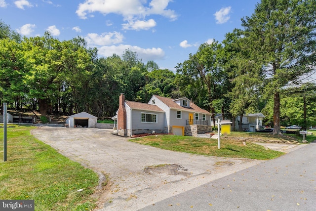 view of front of house featuring a garage, an outbuilding, a front yard, and a carport