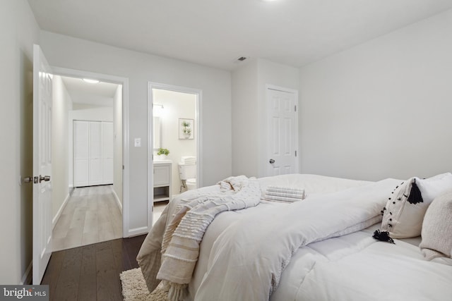 bedroom featuring light hardwood / wood-style flooring and ensuite bathroom