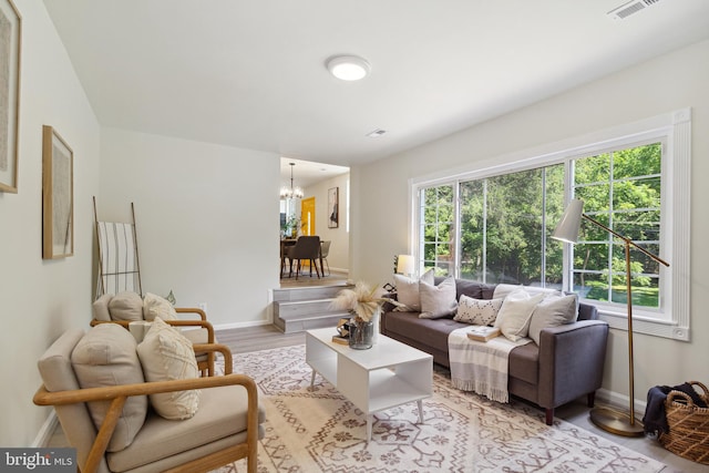 living room featuring a wealth of natural light, a chandelier, and light hardwood / wood-style floors