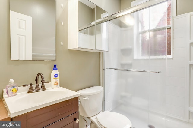 bathroom featuring vanity, toilet, and a shower with door