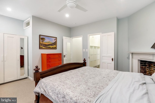 carpeted bedroom with a closet, a fireplace, and ceiling fan