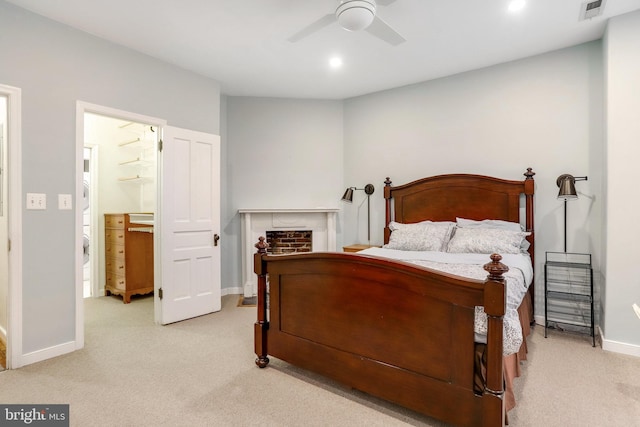 carpeted bedroom with ensuite bathroom and ceiling fan