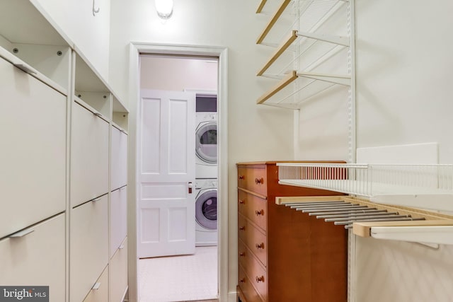 laundry area featuring tile patterned flooring and stacked washer / drying machine