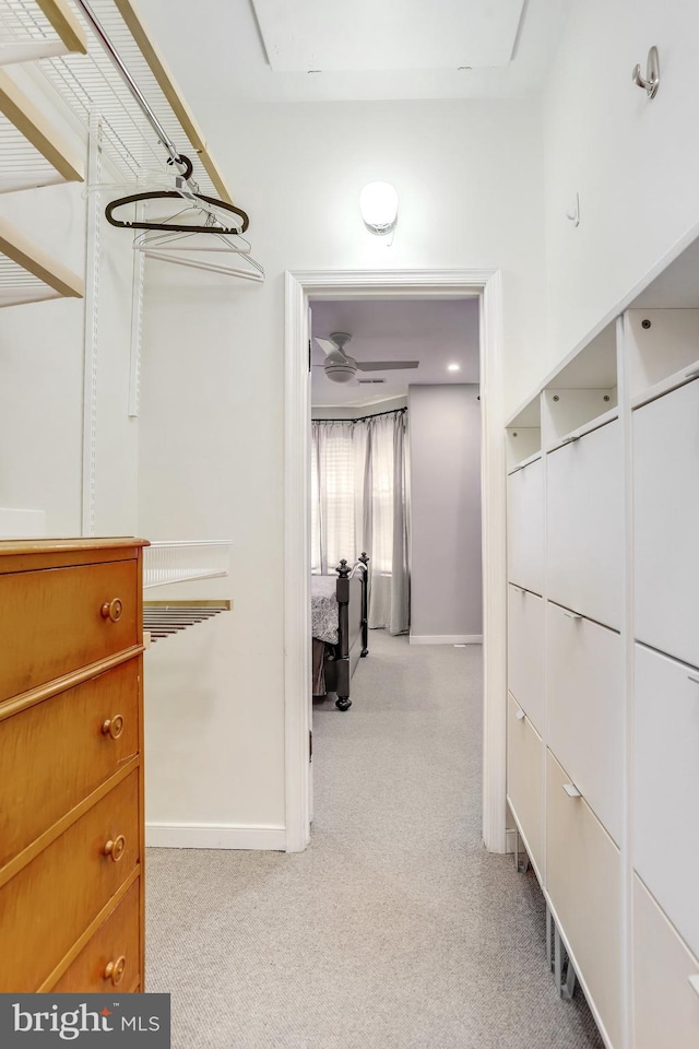 spacious closet with light carpet and ceiling fan