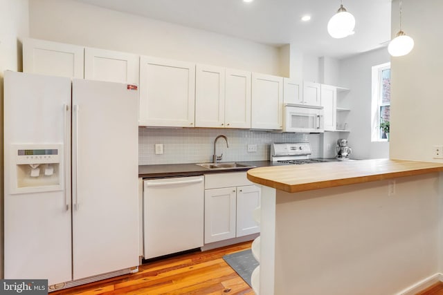 kitchen with butcher block counters, pendant lighting, light wood-type flooring, white appliances, and sink