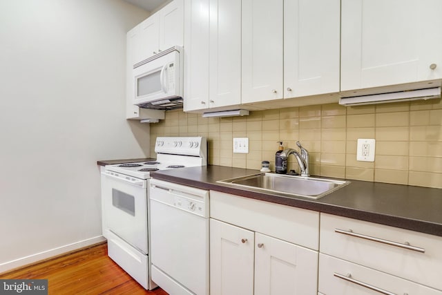 kitchen with white cabinetry, white appliances, light wood-type flooring, backsplash, and sink