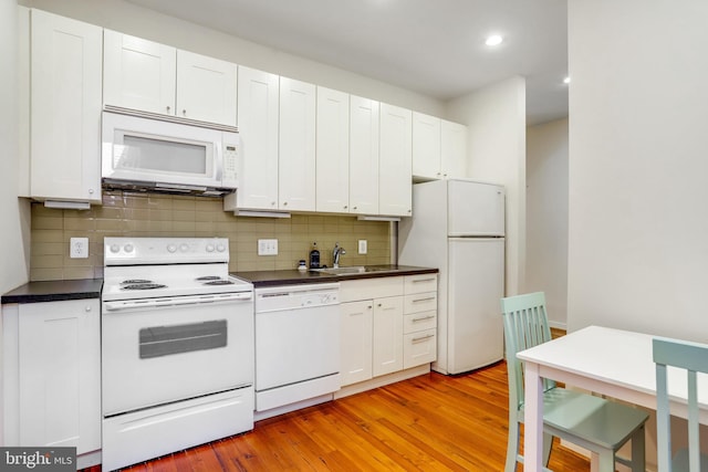 kitchen with white cabinetry, white appliances, light wood-type flooring, decorative backsplash, and sink