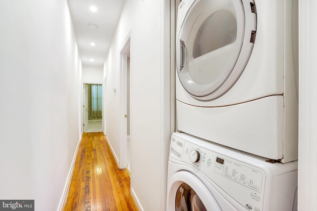 washroom with light wood-type flooring and stacked washer and dryer