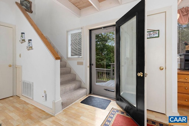 entrance foyer featuring light hardwood / wood-style floors and beamed ceiling