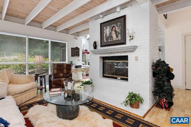 living room featuring hardwood / wood-style flooring, wood ceiling, beam ceiling, and a brick fireplace