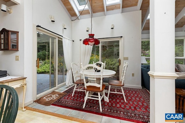 sunroom / solarium featuring vaulted ceiling with skylight, a wealth of natural light, and wooden ceiling