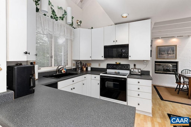 kitchen featuring sink, a fireplace, range with electric cooktop, and white cabinets