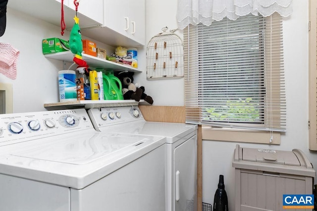 clothes washing area with washing machine and dryer and cabinets