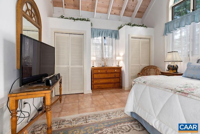 bedroom featuring light tile patterned flooring, high vaulted ceiling, wooden ceiling, two closets, and beamed ceiling