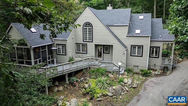 rear view of house with a wooden deck and a sunroom