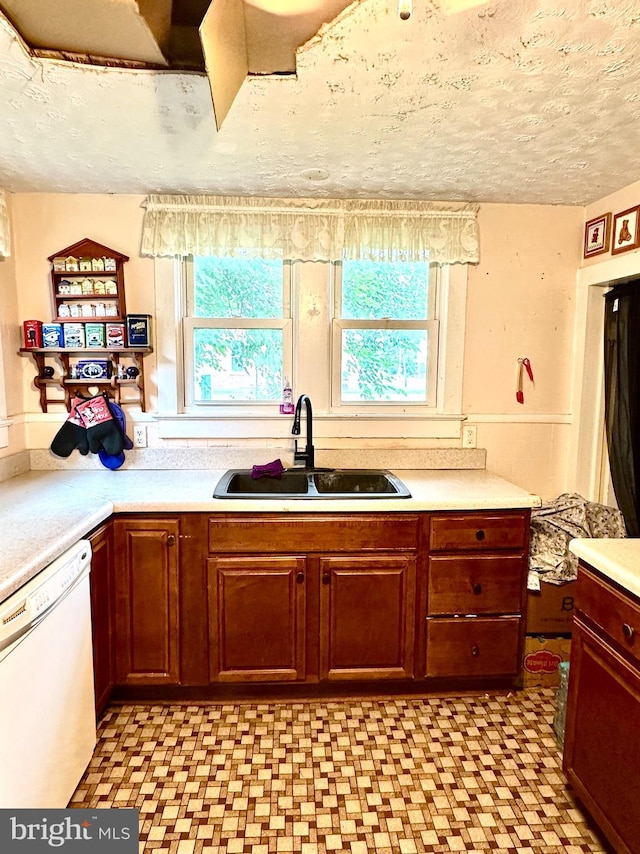 kitchen featuring sink, a textured ceiling, and dishwasher