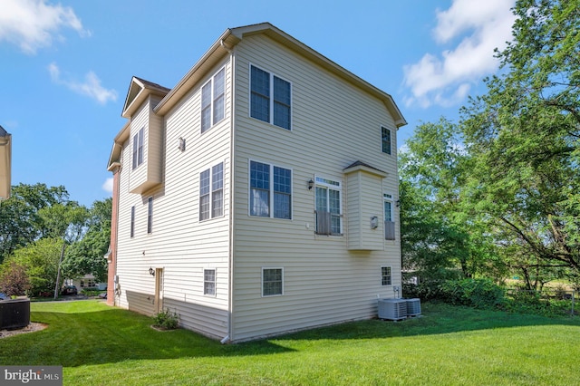 back of property with a lawn and central AC unit