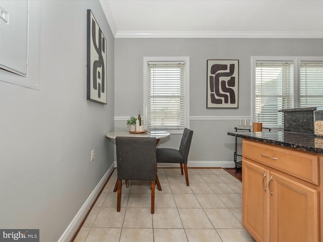 dining area with light tile patterned flooring and crown molding