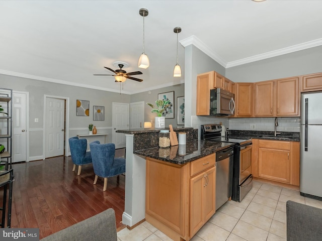 kitchen featuring tasteful backsplash, ceiling fan, crown molding, light wood-type flooring, and appliances with stainless steel finishes