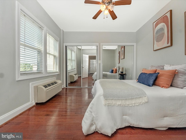 bedroom featuring multiple closets, hardwood / wood-style flooring, and ceiling fan