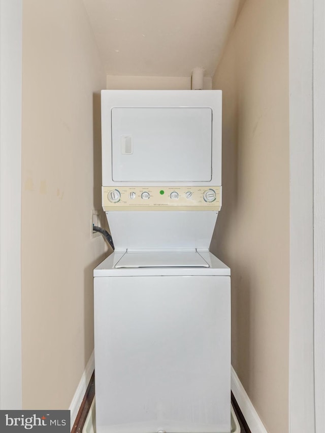 clothes washing area featuring stacked washer / drying machine