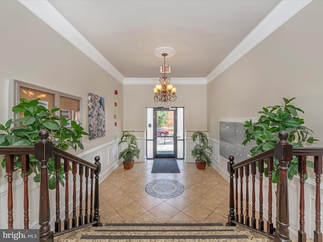 foyer entrance featuring crown molding, light tile patterned floors, and an inviting chandelier