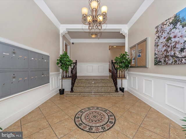 foyer entrance with an inviting chandelier, mail boxes, ornamental molding, and tile patterned floors