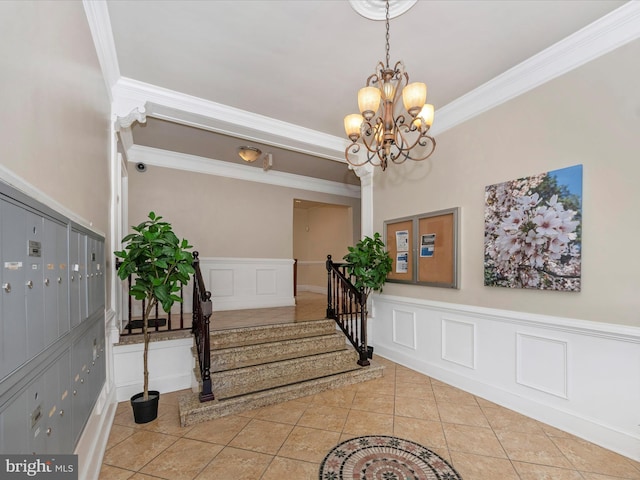 entryway with ornamental molding, an inviting chandelier, and light tile patterned floors