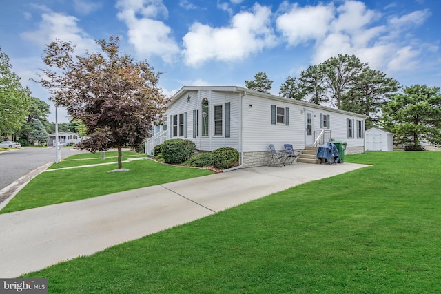 back of property featuring a storage unit and a lawn