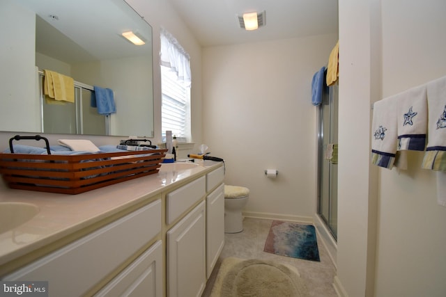 bathroom featuring vanity, toilet, and a shower with shower door