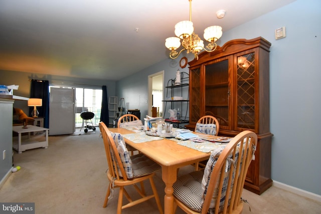 carpeted dining space featuring a notable chandelier