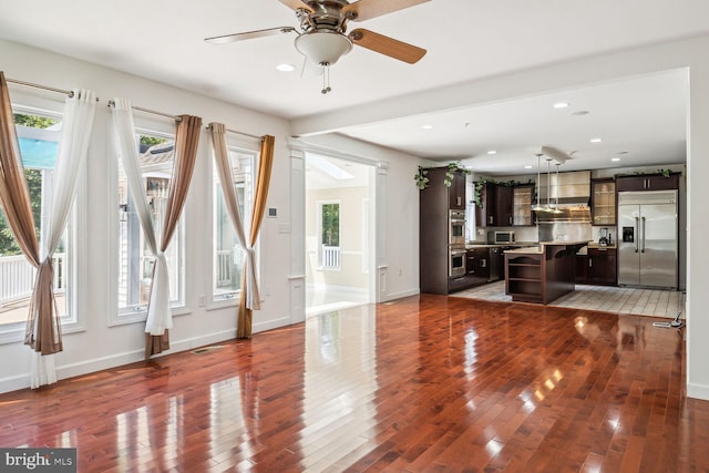 unfurnished living room with hardwood / wood-style flooring and ceiling fan