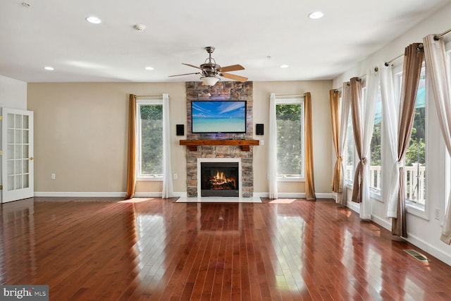 unfurnished living room featuring a fireplace, wood-type flooring, and ceiling fan