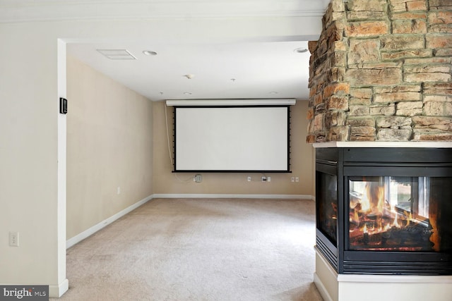 cinema featuring a fireplace and light carpet