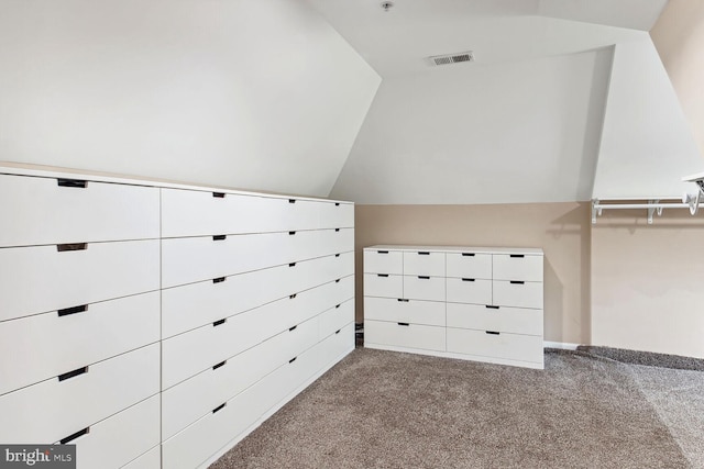 walk in closet with vaulted ceiling and light carpet