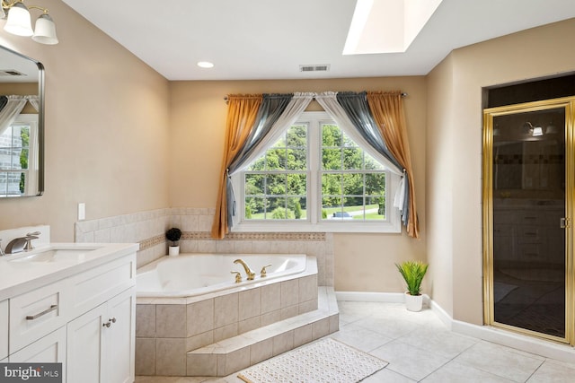 bathroom featuring vanity, plenty of natural light, tile patterned floors, and a skylight