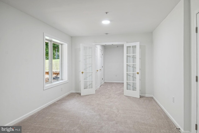 carpeted empty room featuring french doors