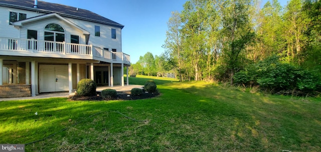 view of yard featuring a wooden deck and a patio