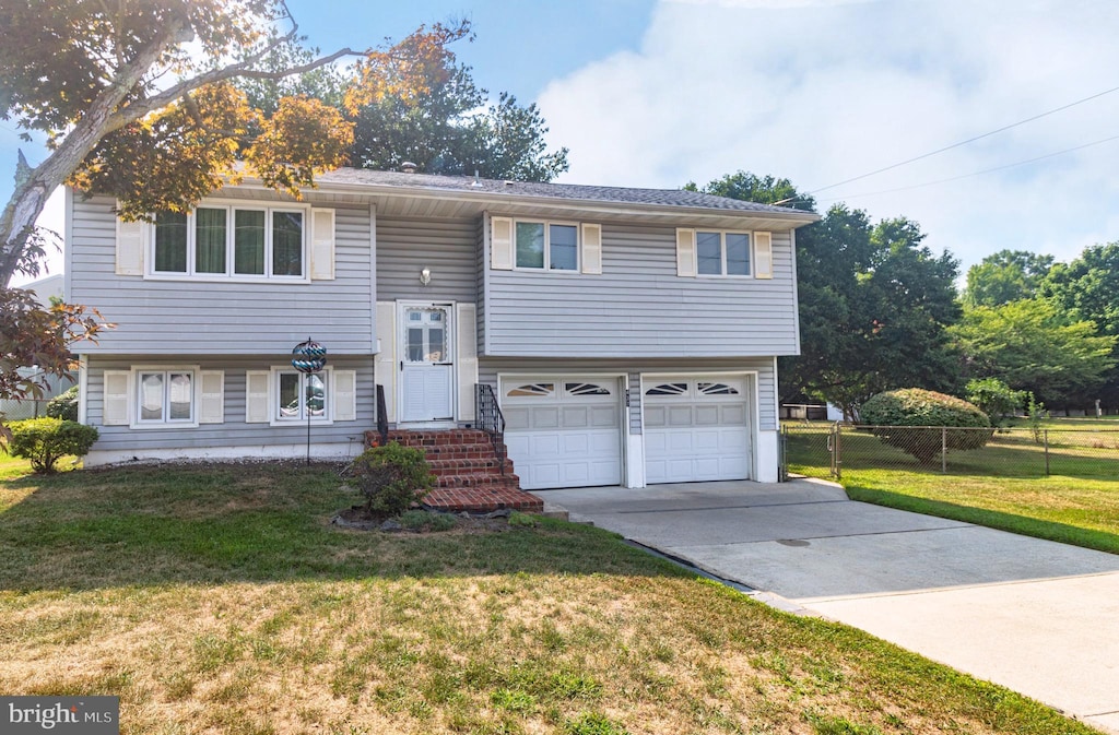 bi-level home featuring a garage and a front lawn