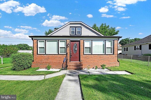 bungalow-style home featuring cooling unit and a front yard