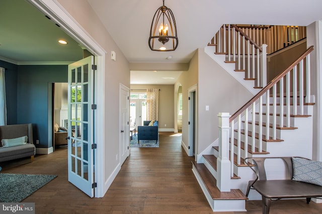 entryway featuring ornamental molding, dark hardwood / wood-style floors, a chandelier, and french doors