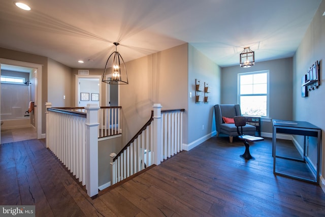 sitting room with dark wood-type flooring and a notable chandelier