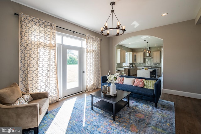 living room featuring an inviting chandelier, sink, and wood-type flooring