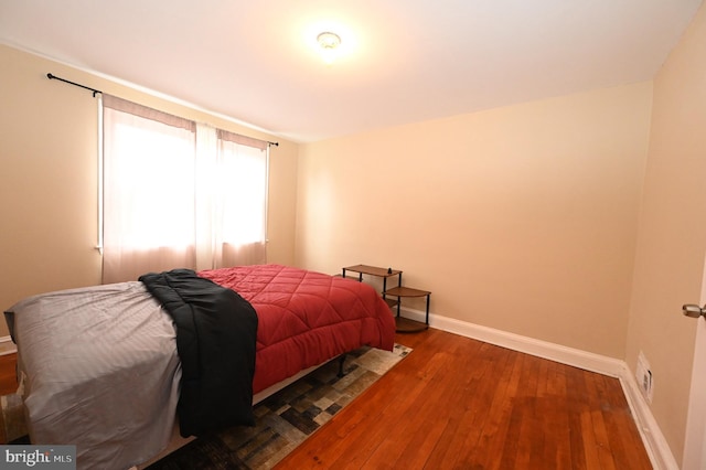 bedroom with dark hardwood / wood-style flooring