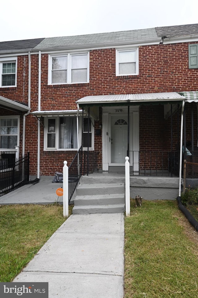 view of property featuring a front yard and a porch