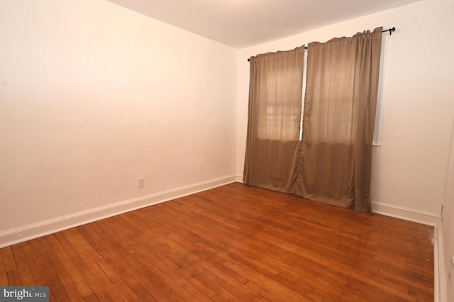 spare room featuring wood-type flooring