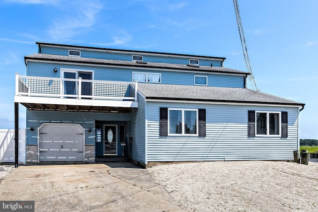 view of front property featuring a balcony and a garage